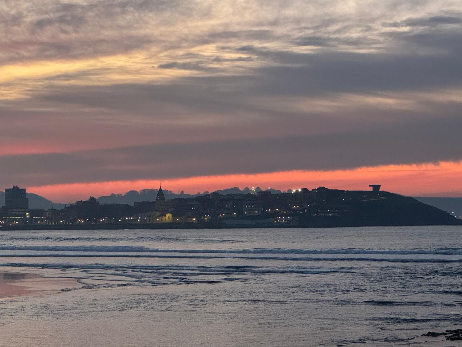 Cimavilla recortada bajo un cielo rojizo antes del amanecer