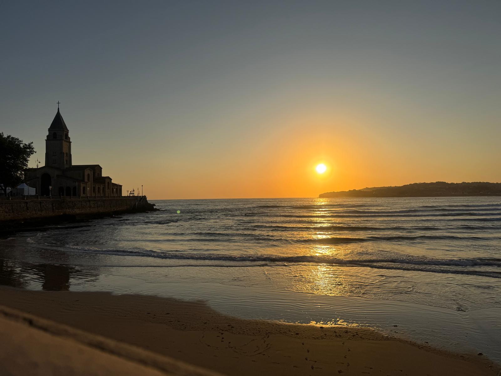 El sol aparece sobre la bahía de San Lorenzo junto a la iglesia de San Pedro